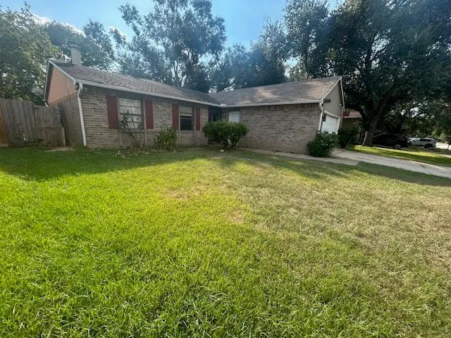 a view of a house with backyard and trees