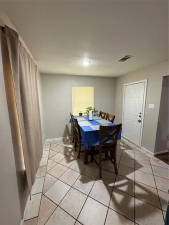 a living room with furniture a flat screen tv and kitchen view