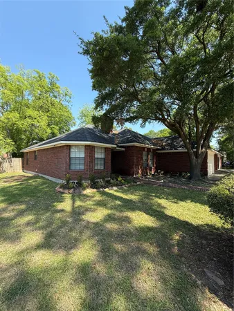 a front view of a house with a yard and a tree