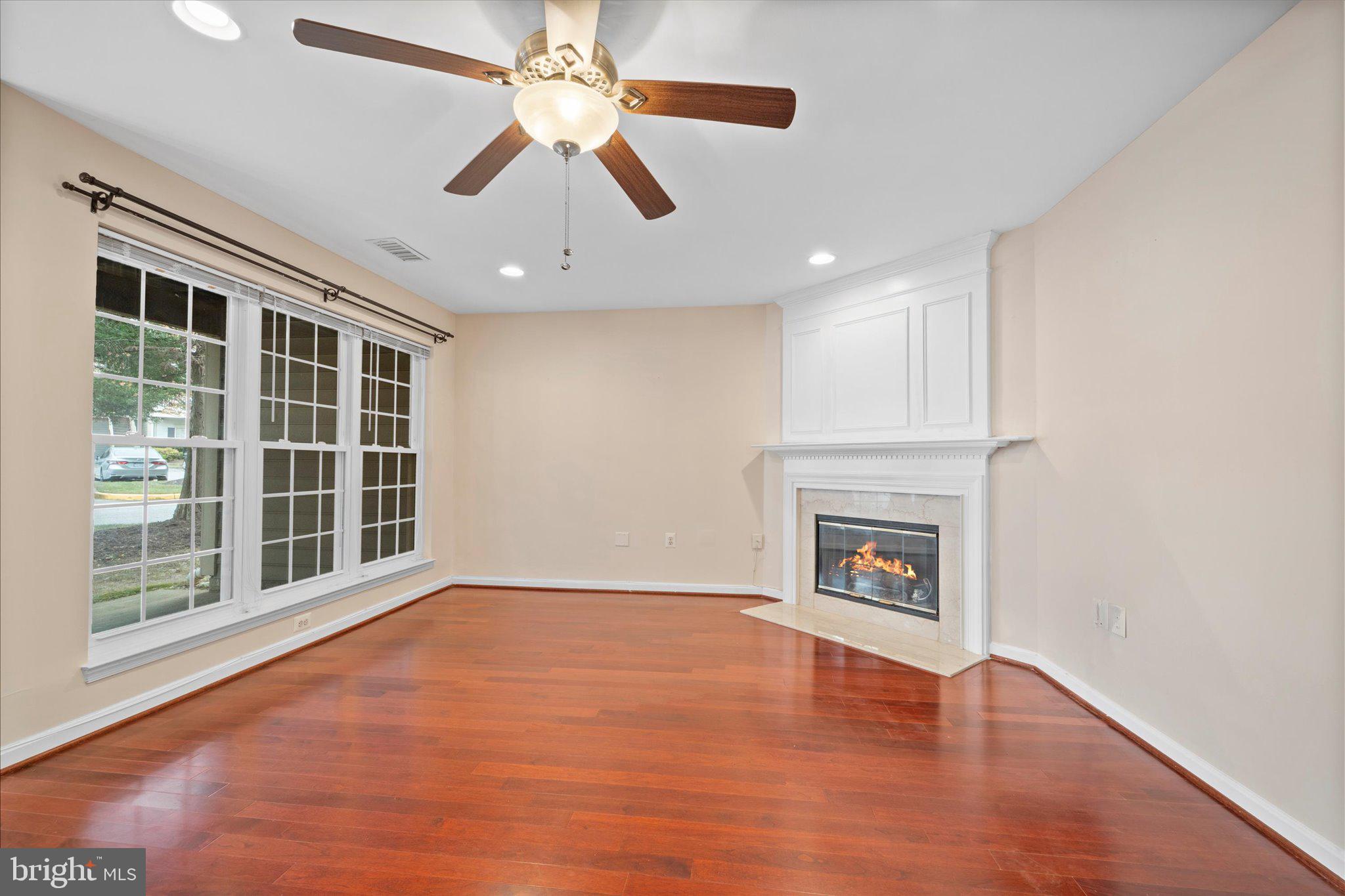 9253 Cardinal Forest Lane, Unit 101 Lorton, VA 22079 - Photo 17 of 29 a view of an empty room with wooden floor fireplace and a window