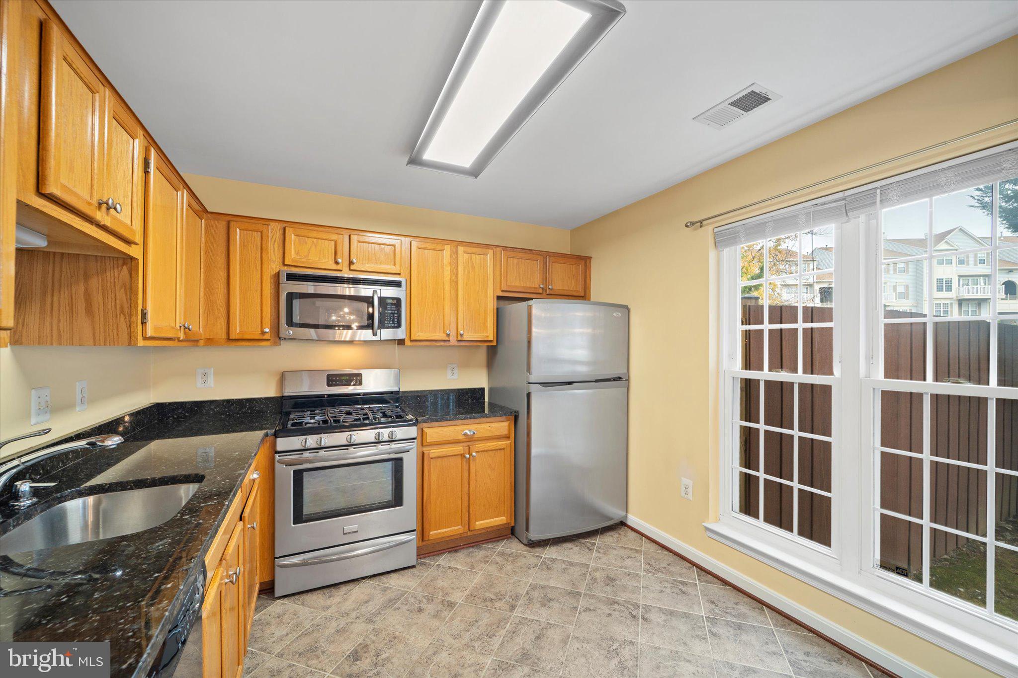 9253 Cardinal Forest Lane, Unit 101 Lorton, VA 22079 - Photo 2 of 29 a kitchen with stainless steel appliances granite countertop a stove a sink and a refrigerator