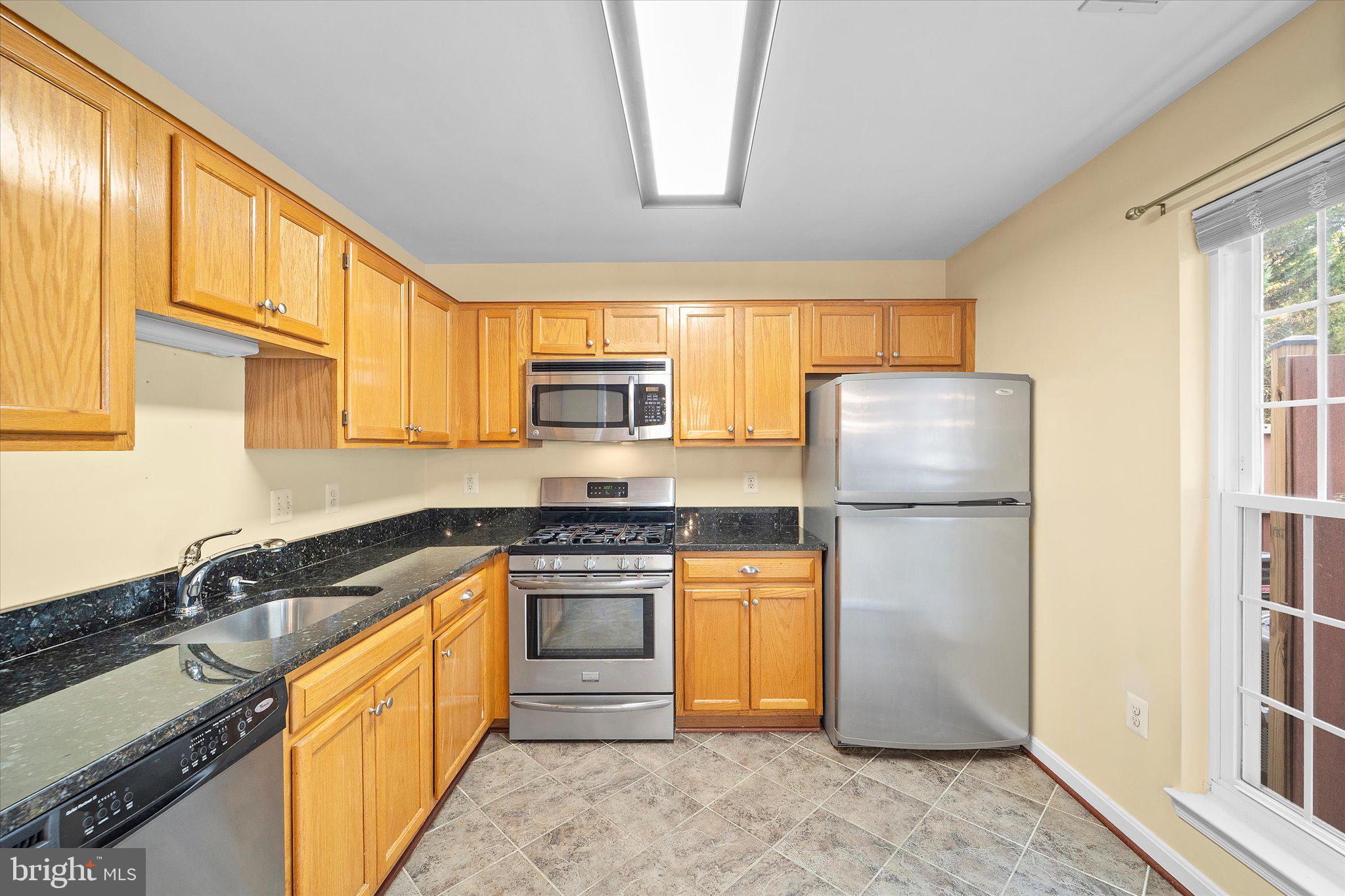 9253 Cardinal Forest Lane, Unit 101 Lorton, VA 22079 - Photo 6 of 29 a kitchen with stainless steel appliances granite countertop a refrigerator stove and sink