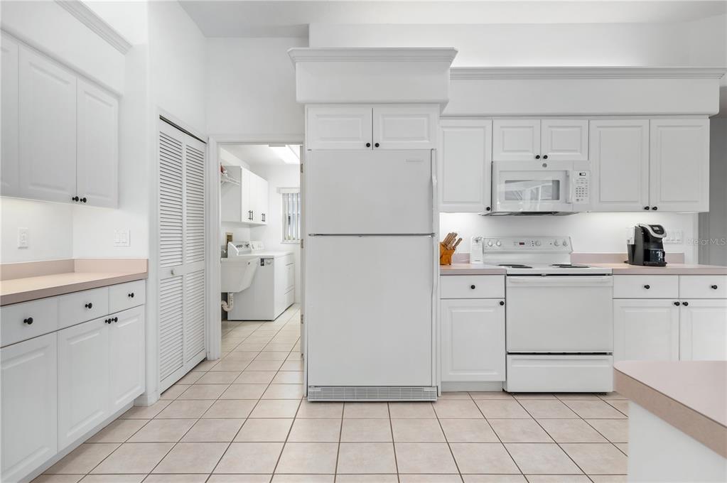 2810 89th Avenue East Parrish, FL 34219 - Photo 14 of 34 a kitchen with cabinets and a refrigerator