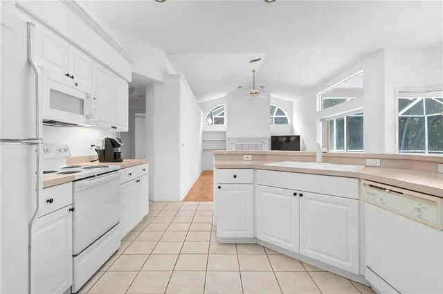 a large white kitchen with cabinets
