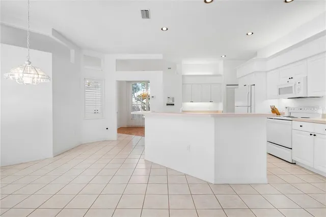 a kitchen with white cabinets and white appliances