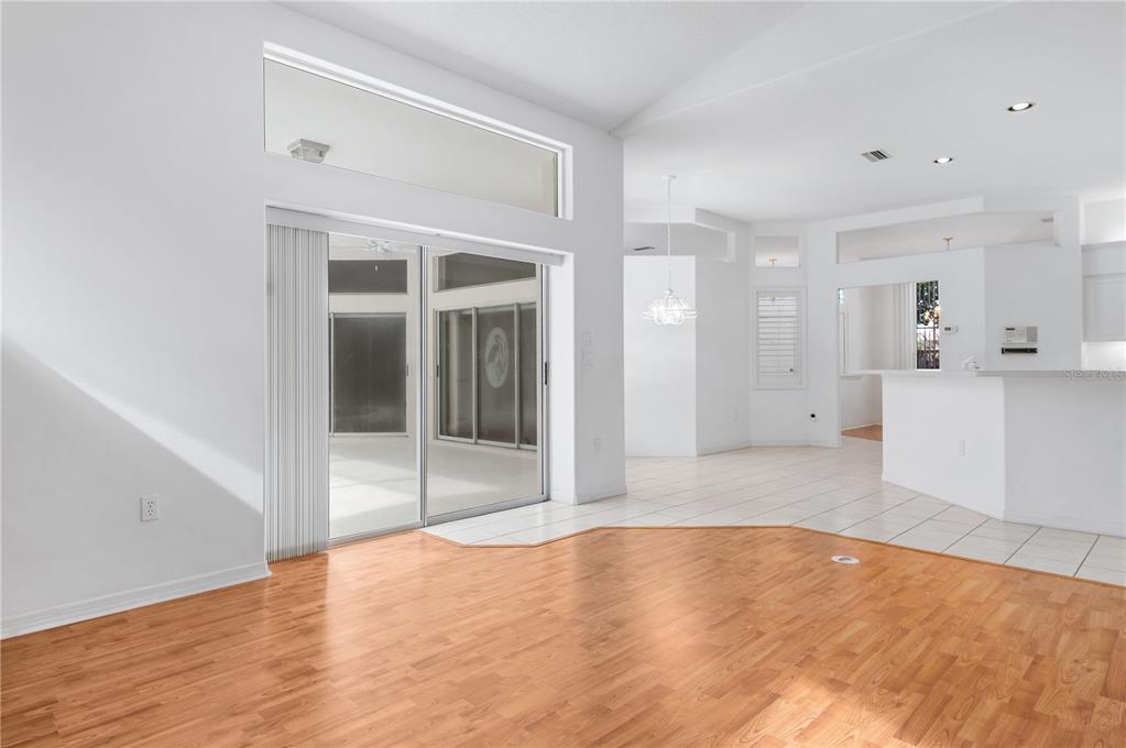 2810 89th Avenue East Parrish, FL 34219 - Photo 19 of 34 a view of an empty room with wooden floor and a kitchen