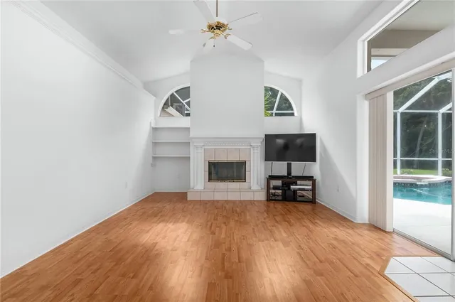 a view of empty room with fireplace and wooden floor