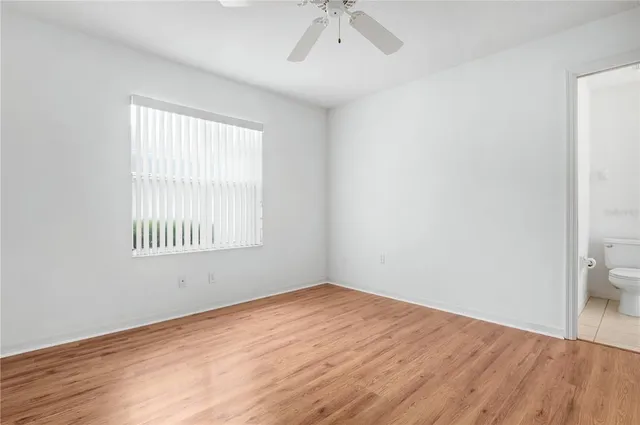 an empty room with a bathroom and a window