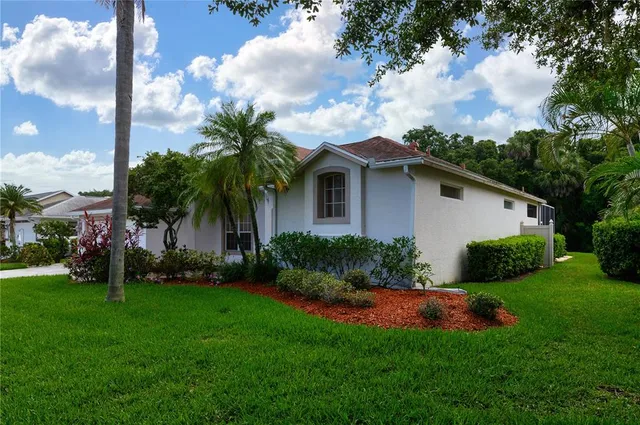 a view of a house with a yard and potted plants