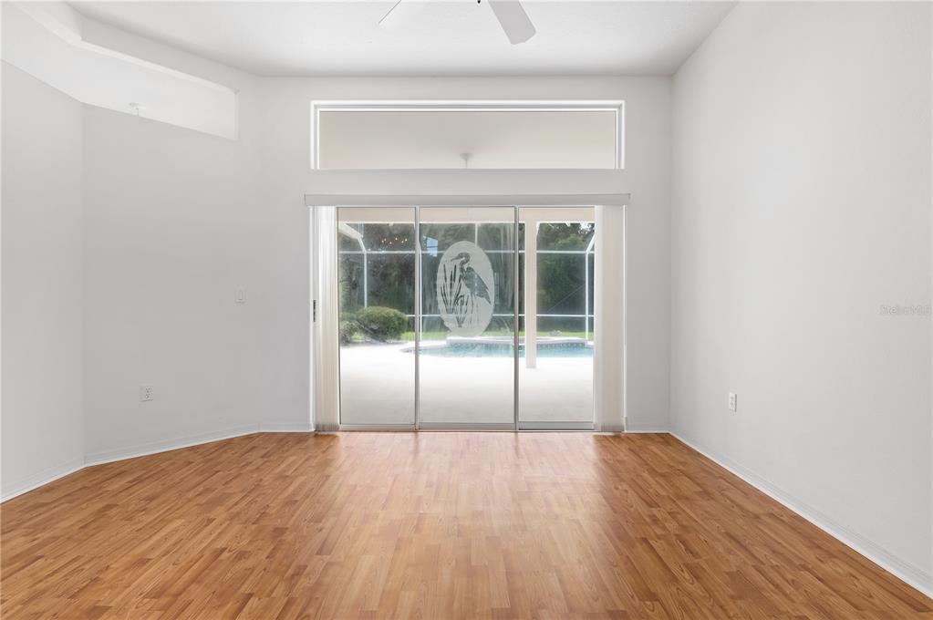 2810 89th Avenue East Parrish, FL 34219 - Photo 5 of 34 a view of an empty room with wooden floor and a window