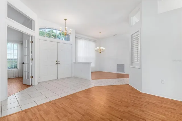 a view of an empty room with wooden floor and a bathroom