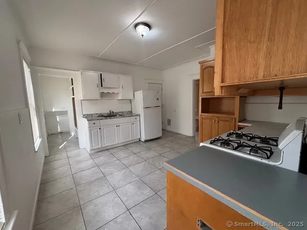 a kitchen with a stove a refrigerator and cabinets