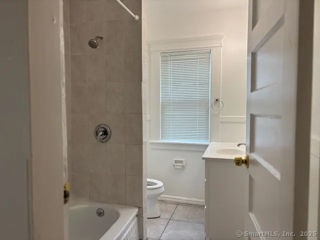 a bathroom with a granite countertop sink a toilet and shower
