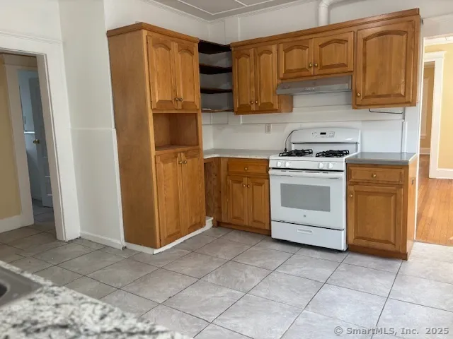 a kitchen with stainless steel appliances granite countertop a stove a refrigerator and a sink