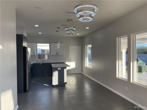a large kitchen with a large window and stainless steel appliances