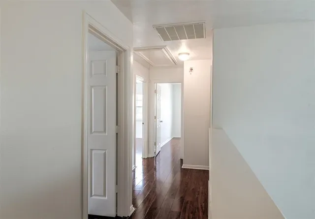 a view of a hallway with wooden floor and staircase