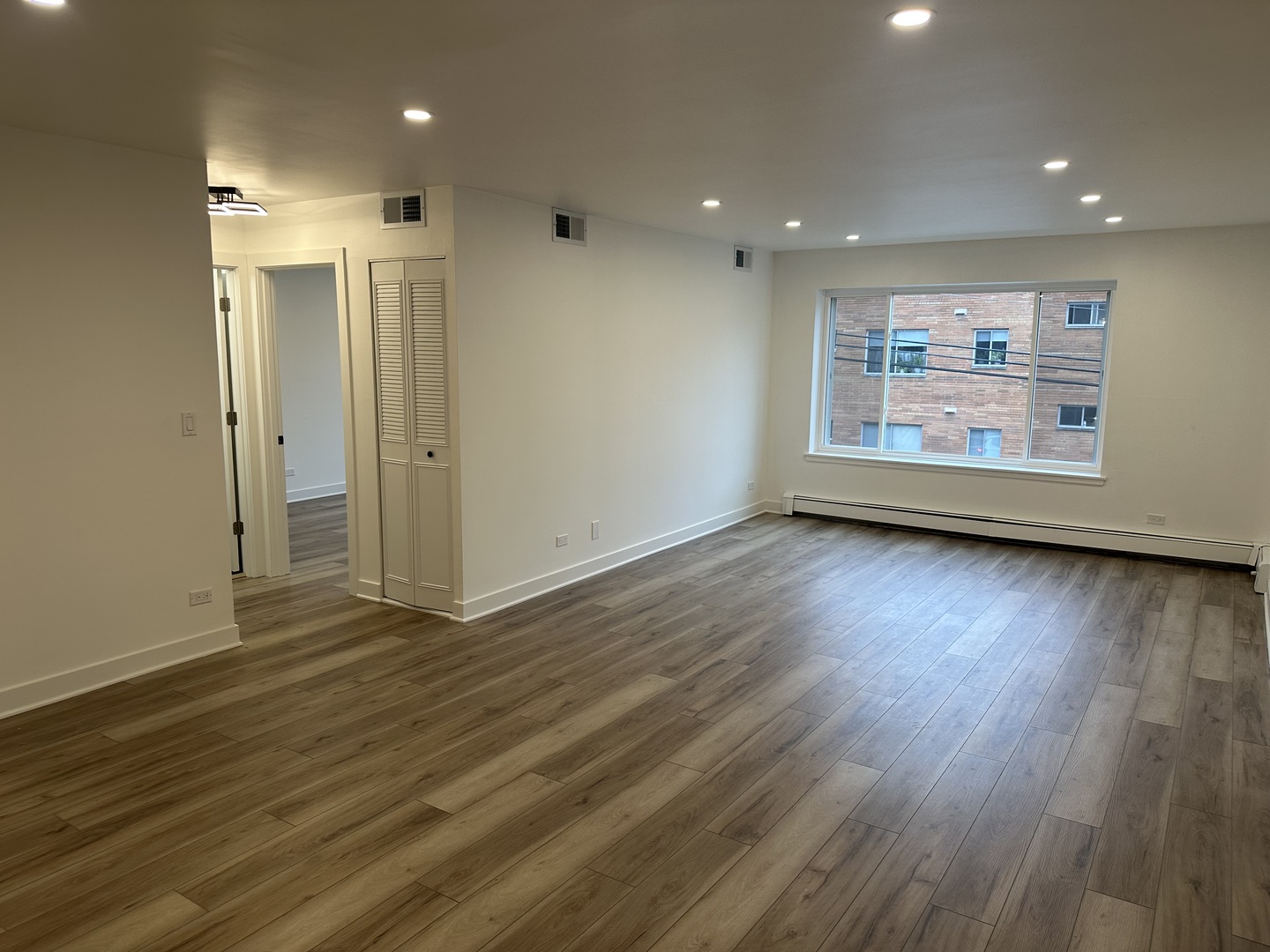 8232 Niles Center Road, Unit 202 Skokie, IL 60077 - Photo 2 of 8 an empty room with wooden floor and window