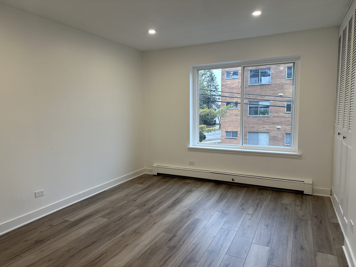 8232 Niles Center Road, Unit 202 Skokie, IL 60077 - Photo 5 of 8 a view of an empty room with wooden floor and a window
