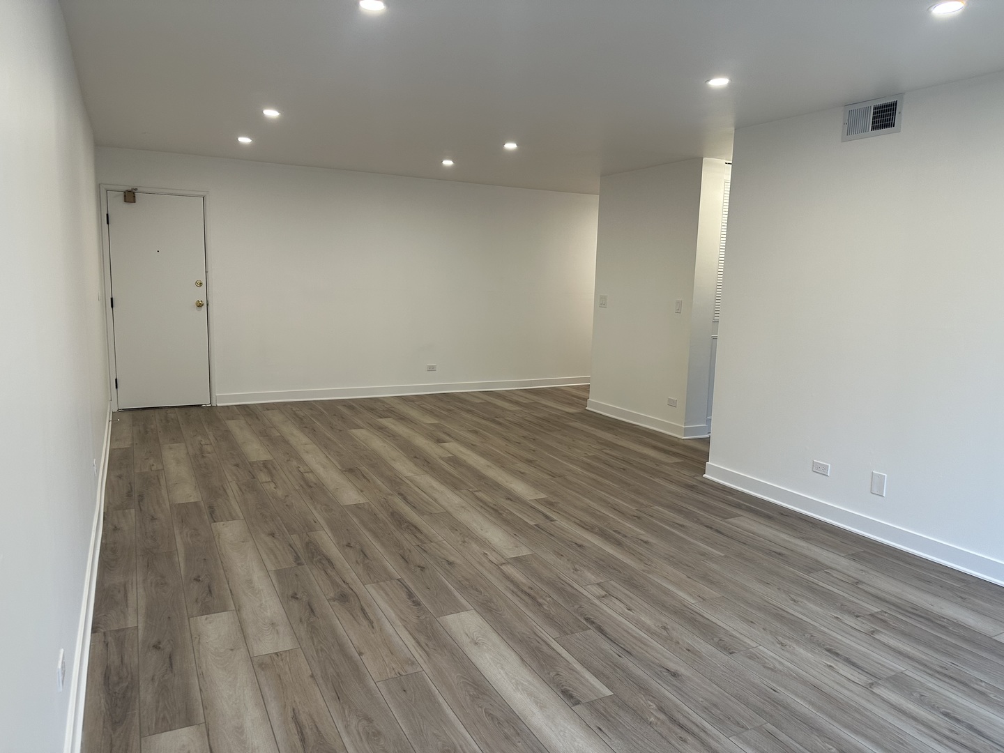 8232 Niles Center Road, Unit 202 Skokie, IL 60077 - Photo 7 of 8 an empty room with wooden floor and windows