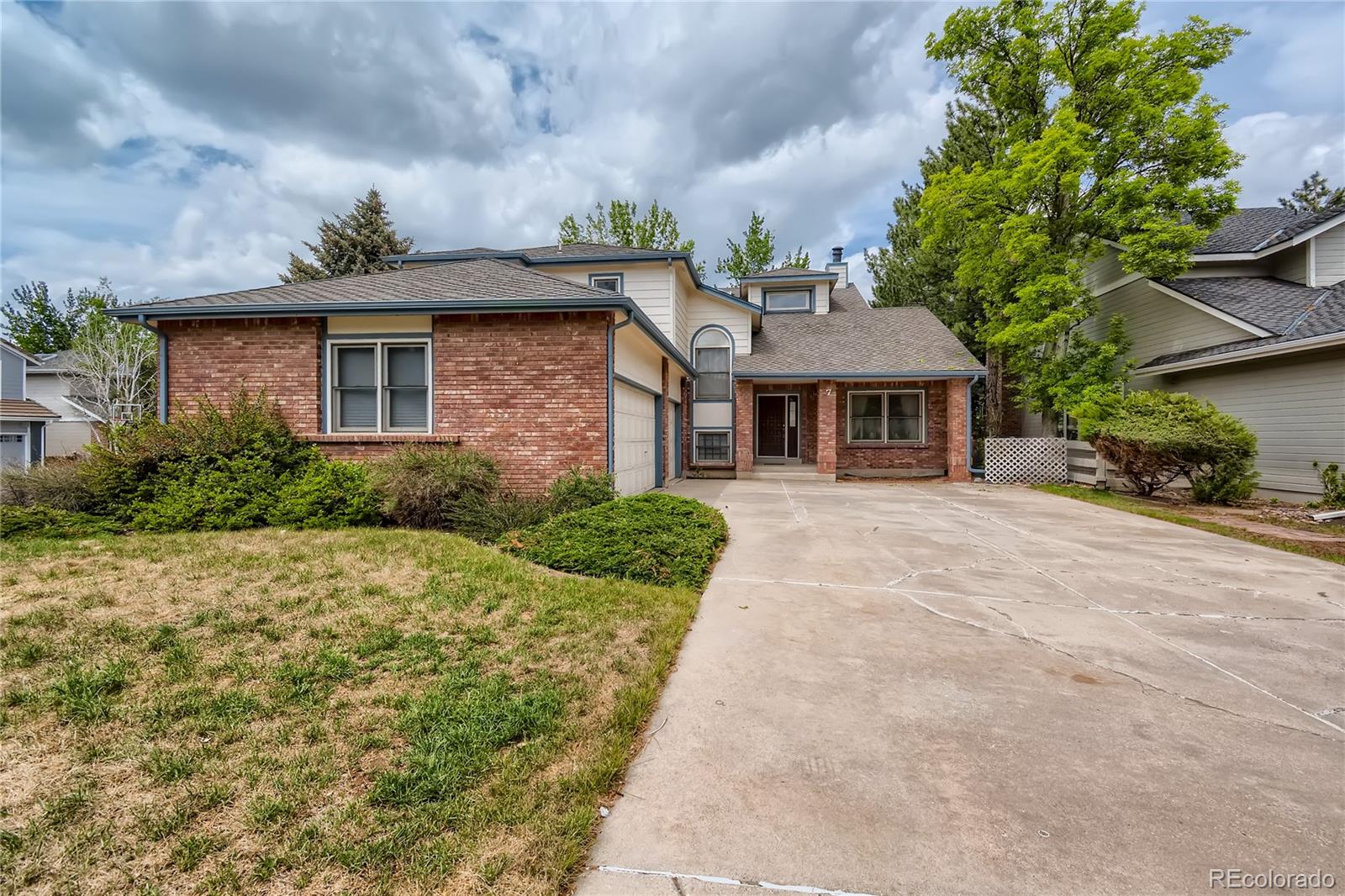 7 Red Maple Place Littleton, CO 80127 - Photo 2 of 28 a front view of a house with a yard and potted plants