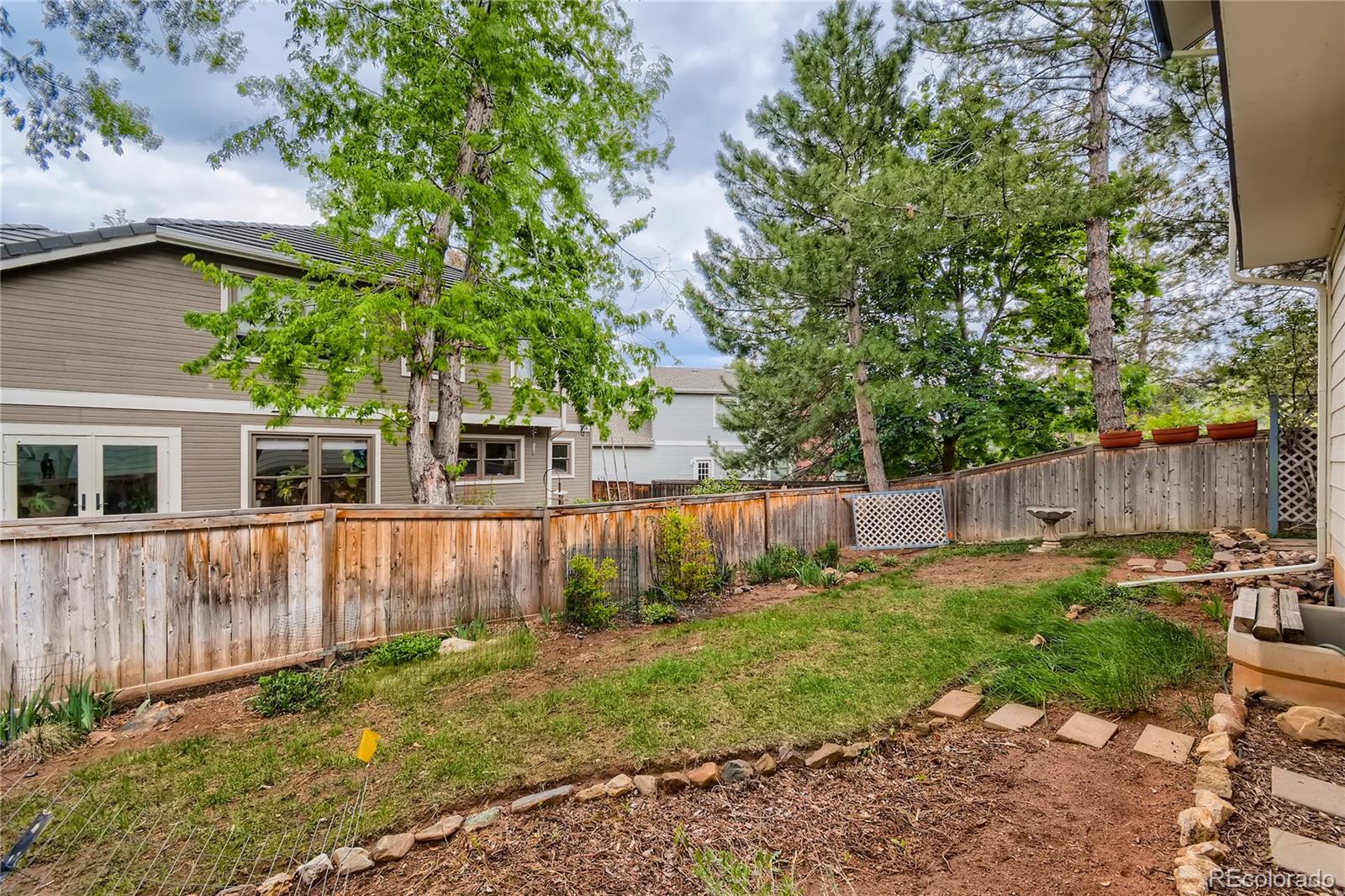 7 Red Maple Place Littleton, CO 80127 - Photo 27 of 28 a view of a backyard with plants and wooden fence