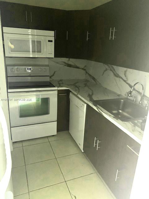 13714 Southwest 90th Avenue, Unit 25 Miami, FL 33176 - Photo 5 of 15 a stove top oven sitting inside of a kitchen