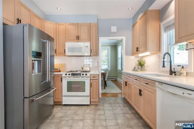 a kitchen with stainless steel appliances a refrigerator sink and cabinets