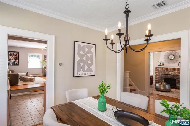 a view of a livingroom with furniture a chandelier and wooden floor