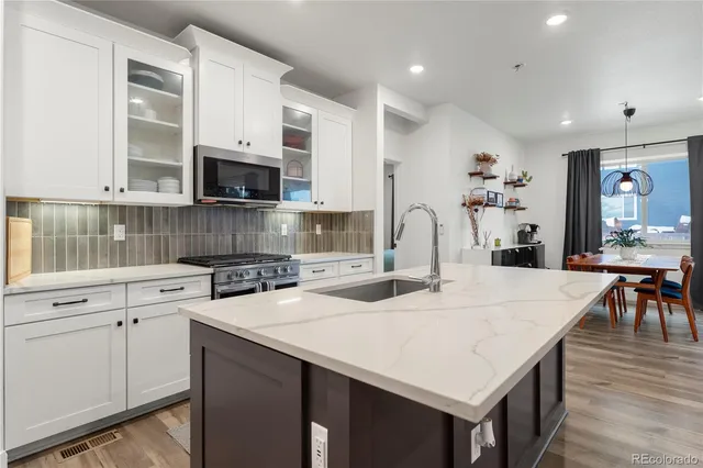 a kitchen with a sink a microwave and cabinets