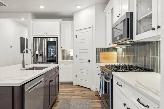 a kitchen with stainless steel appliances granite countertop a stove a sink and a refrigerator