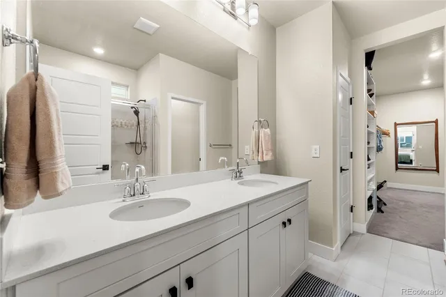 a bathroom with a sink double vanity granite tub shower and mirror