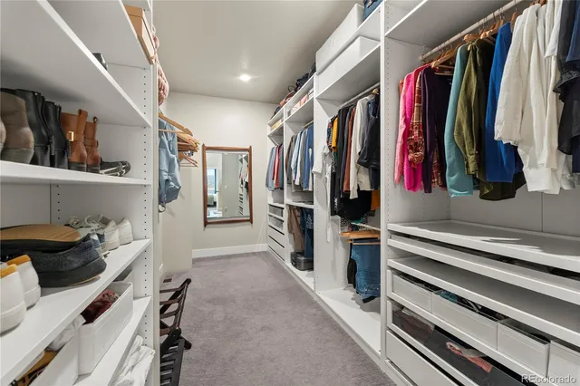 a view of walk in closet with clothes and shoes
