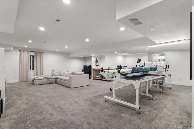 a living room with furniture a table and kitchen view