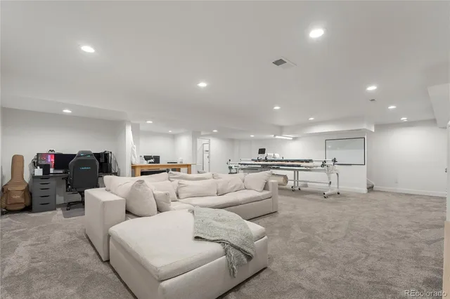 a living room with furniture and a view of kitchen