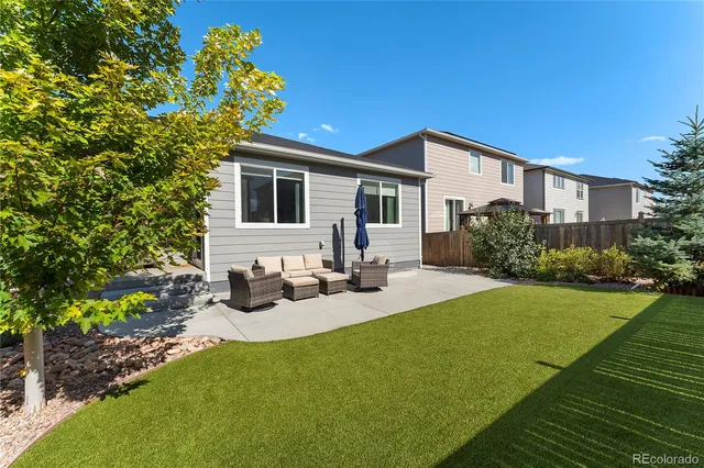 a view of a house with backyard and sitting area