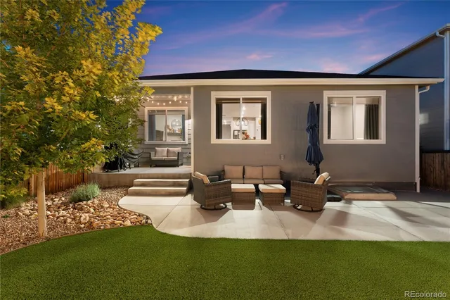 a view of a house with backyard and sitting area