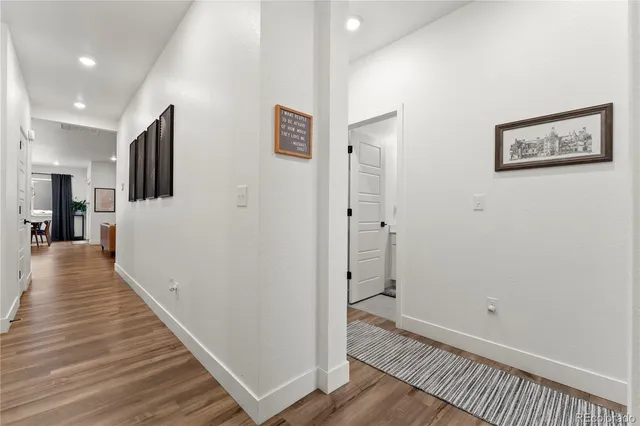 a view of a hallway with wooden floor and staircase
