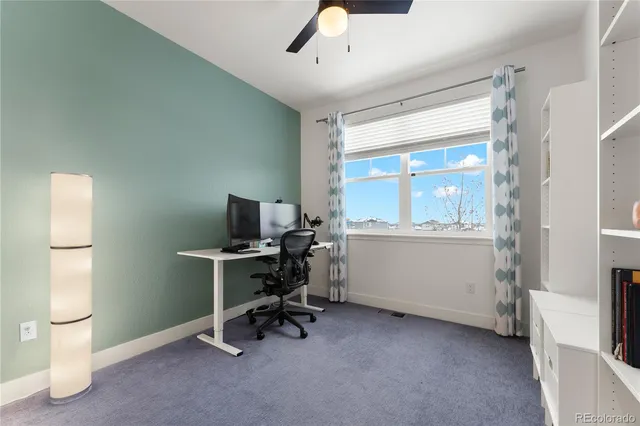 a view of a workspace with furniture and a window