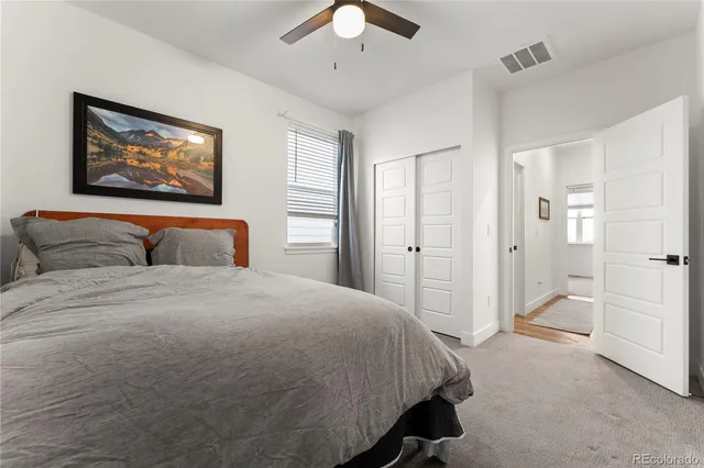 a spacious bedroom with a bed and a painting on the wall