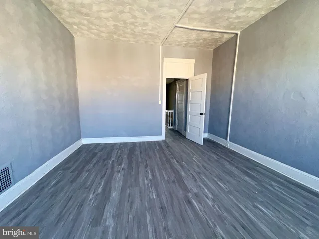 a view of a room with wooden floor and a window