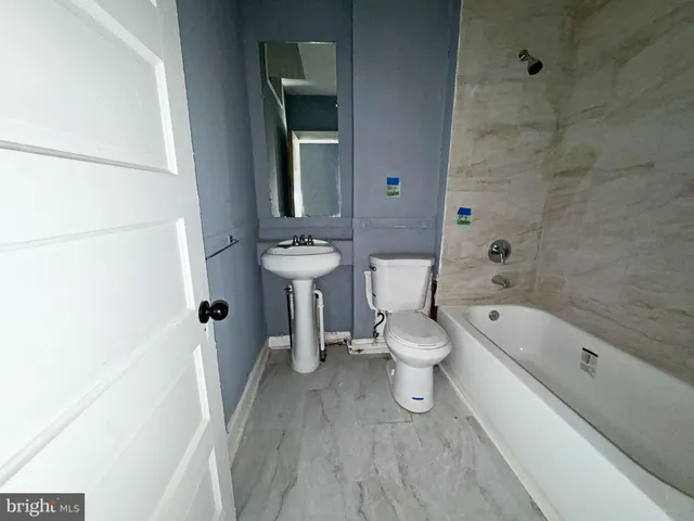a bathroom with a sink a toilet and bathtub