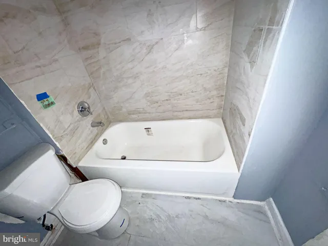 a bathroom with a tub and toilet