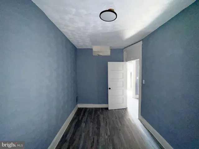 a view of a room with wooden floor and white walls