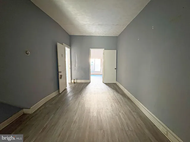 a view of empty room with wooden floor