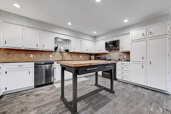 a kitchen with cabinets stainless steel appliances and a window