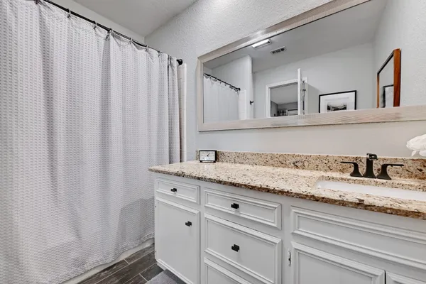 a bathroom with a granite countertop sink and vanity