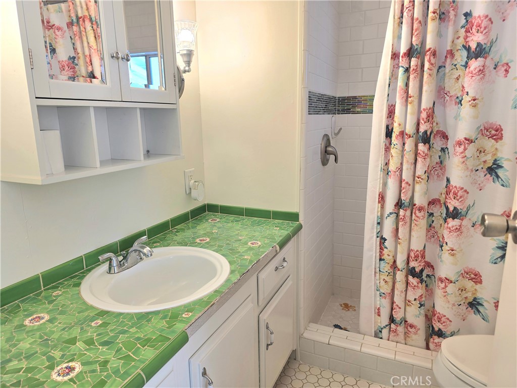 6271 East Sea Breeze Drive, Unit 36 Long Beach, CA 90803 - Photo 13 of 34 a bathroom with a granite countertop sink and a mirror