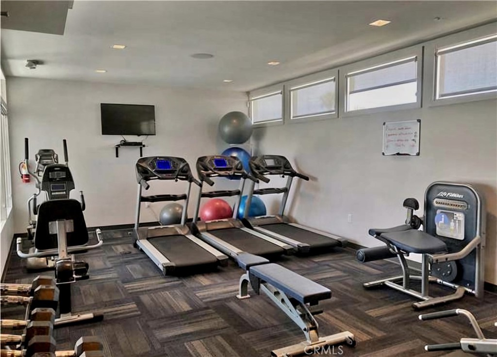 6271 East Sea Breeze Drive, Unit 36 Long Beach, CA 90803 - Photo 27 of 34 a room with gym equipment and a flat screen tv