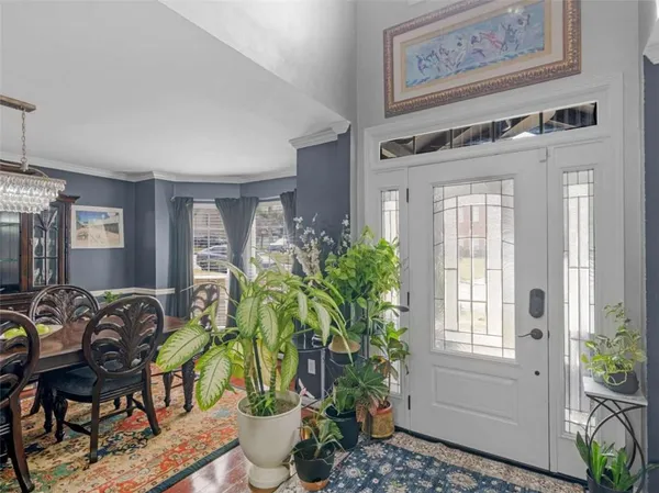 a dining room with wooden floor a chandelier a wooden table and chairs