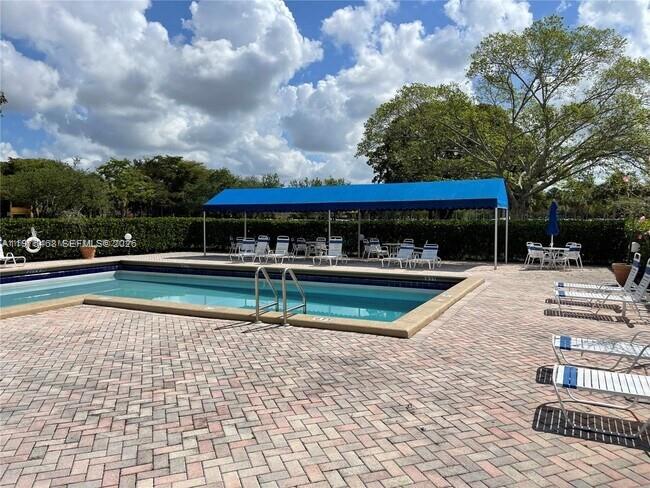 16500 Golf Club Road, Unit 205 Weston, FL 33326 - Photo 3 of 18 a view of a swimming pool with sitting area and furniture